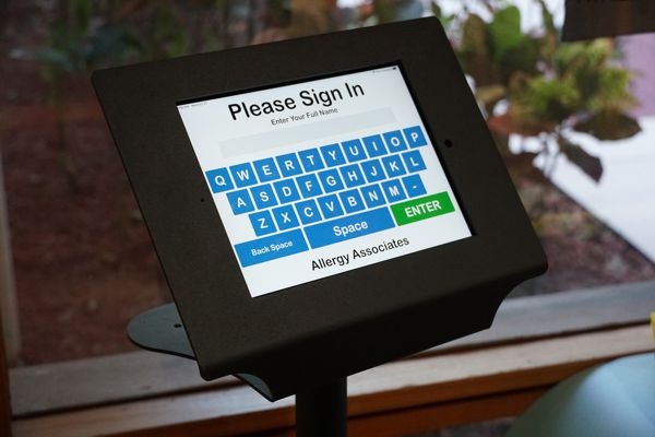 Ipad floor stand with medical check in app displayed.